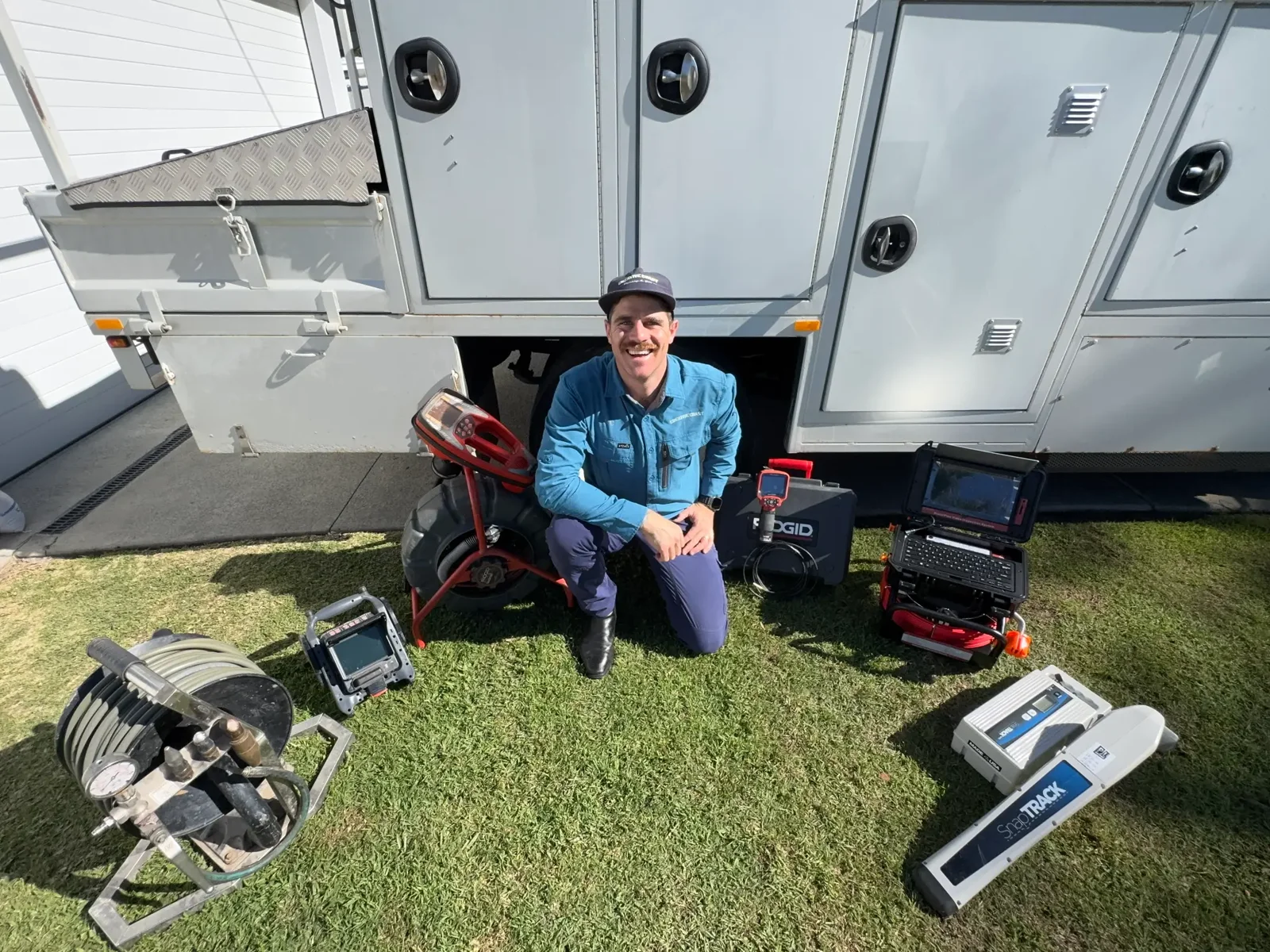 Nic from Creative Coast Plumbing & Gas with CCTV drain cameras, jetter and locator equipment beside the service truck
