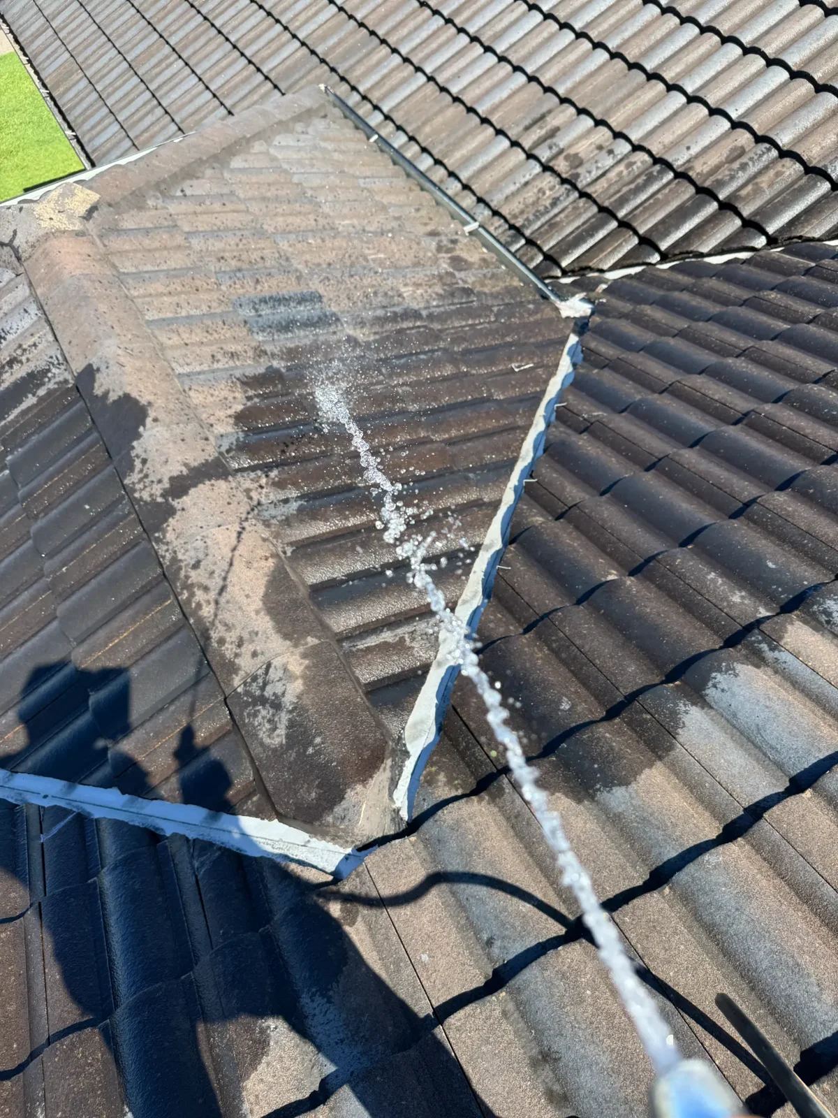 Water testing a tiled roof valley to pinpoint the source of a roof leak on a Gold Coast home