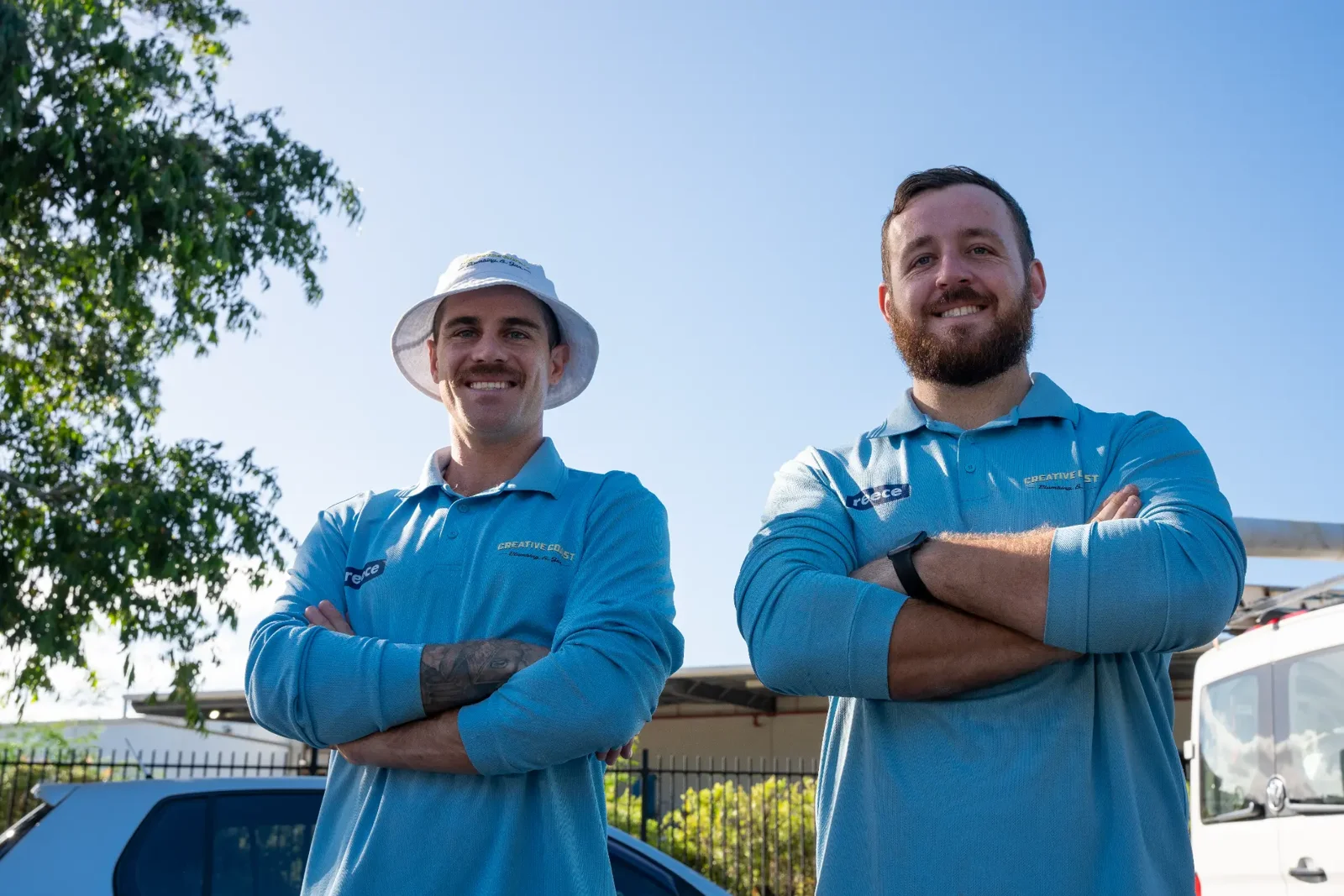 Two Creative Coast Plumbing & Gas team members in uniform in front of the service van on the Gold Coast